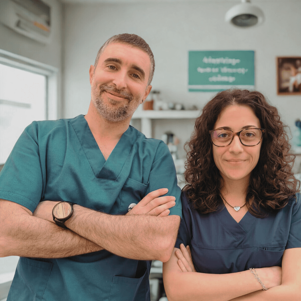 Dos profesionales de la salud sonrientes, con uniforme, en un entorno clínico.